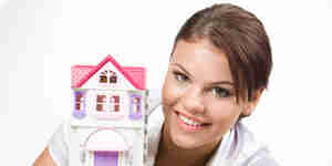 Jeune femme avec une maison de poupée
