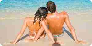 Couple assis sur la plage de sable